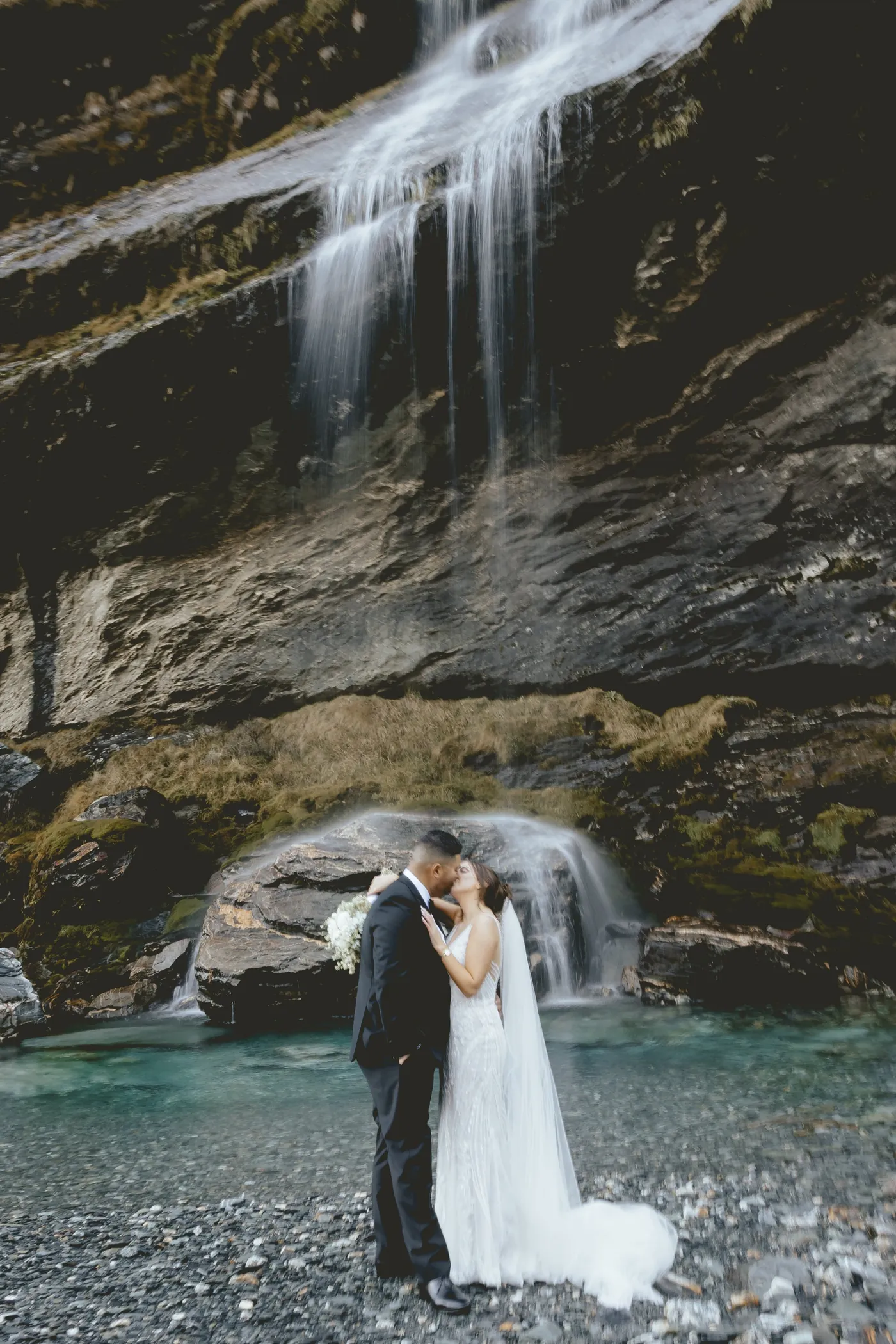 Wedding party celebrating with champagne above a Queenstown lake